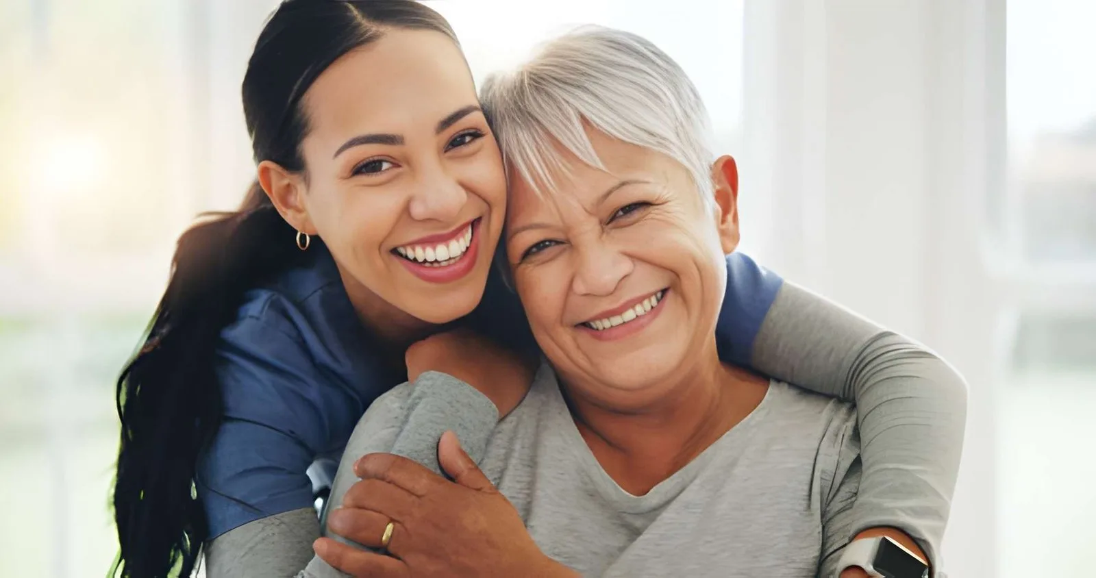 Caregiver warmly embracing an older adult