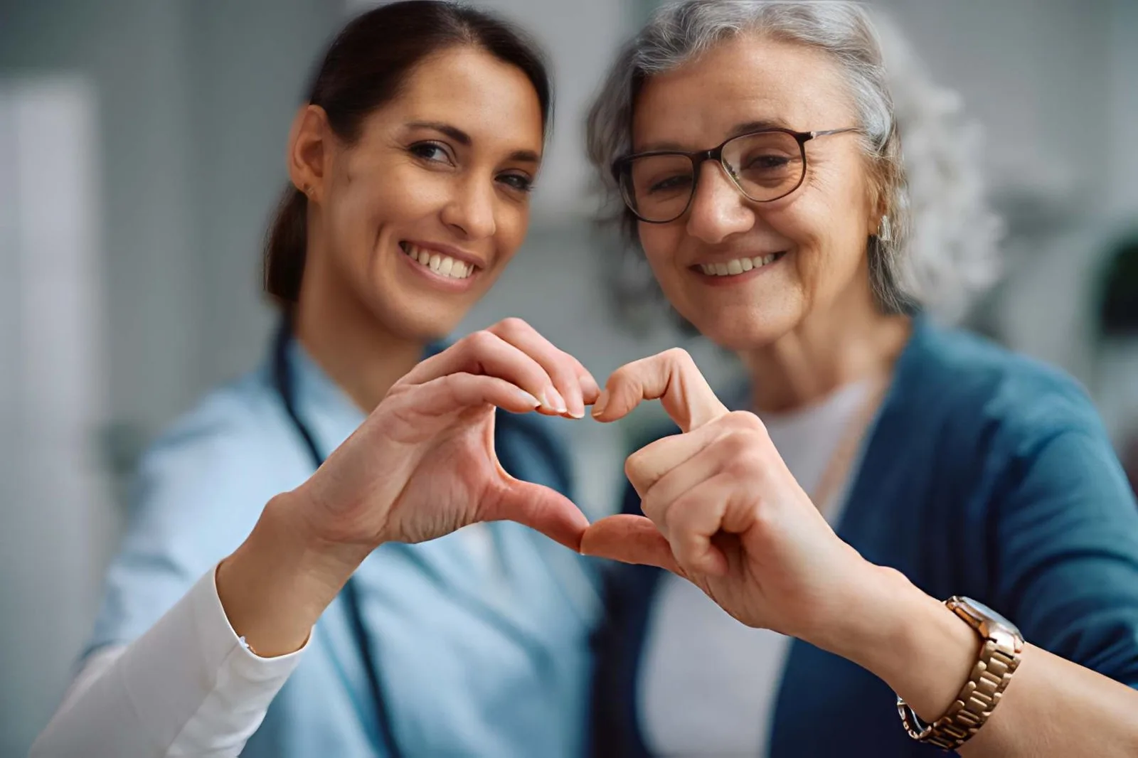 Caregiver and older adult making a heart shape together