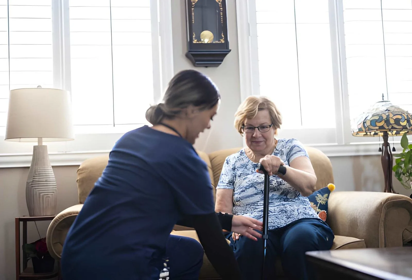 Caregiver sitting with an older adult in a comfortable home setting
