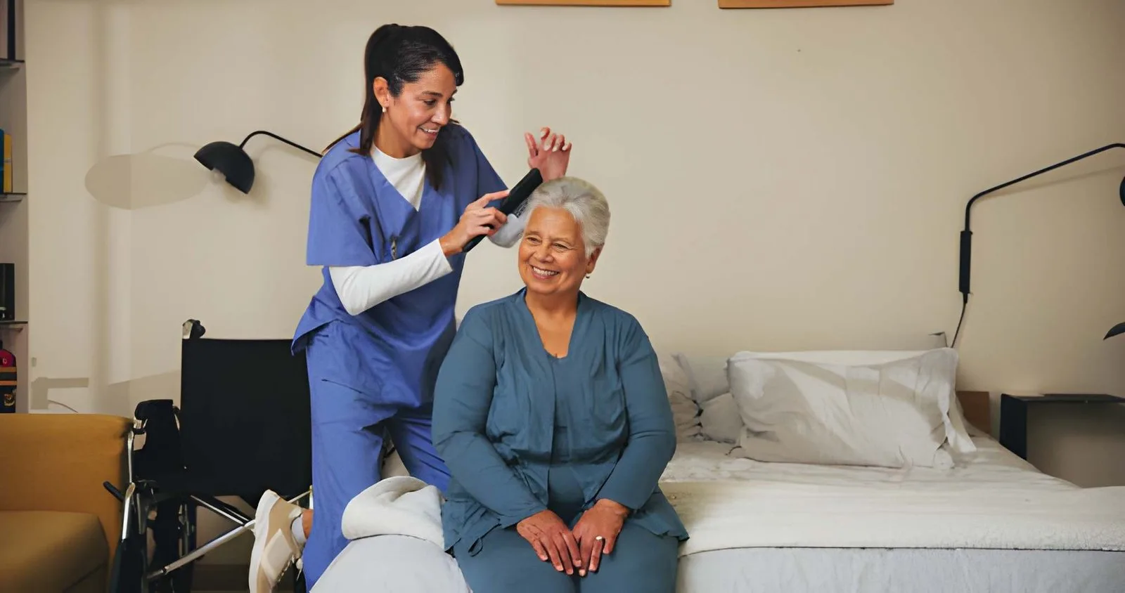 Caregiver supporting an older adult in a bedroom at home