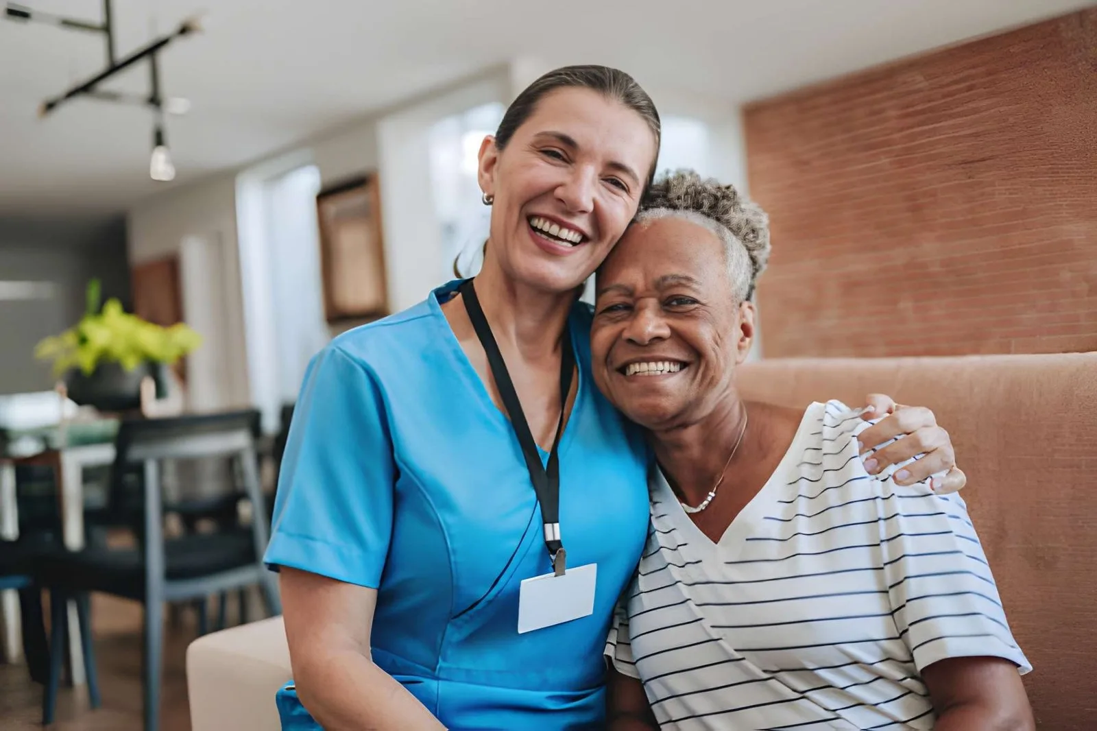 Care professional and older adult smiling together